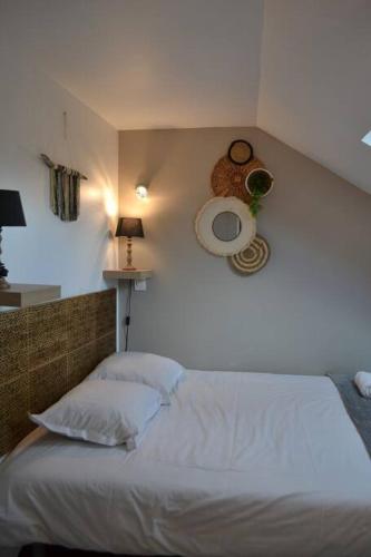 une chambre avec un lit blanc et un mur dans l'établissement Appartement Le Filaterie sous les toits, à Annecy