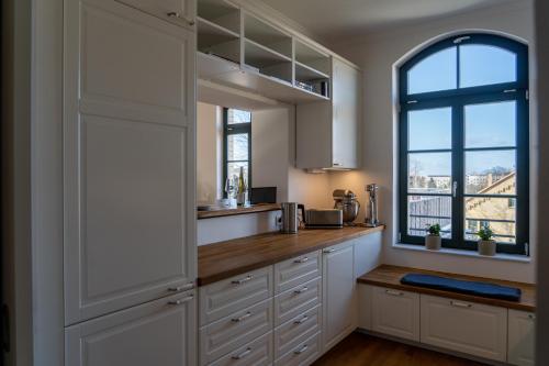 a kitchen with white cabinets and a window at König Albert Residenz nahe BMW , Porsche , DHL und Messe in Leipzig