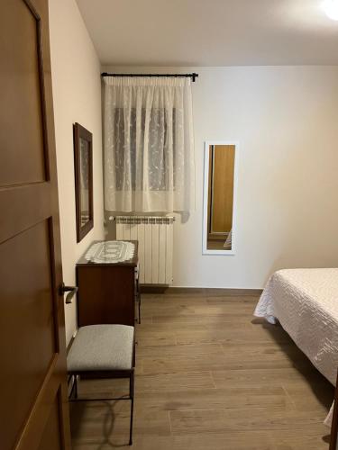 a bedroom with a bed and a desk and a window at Casa Rural De Mascoras in Santibáñez el Alto