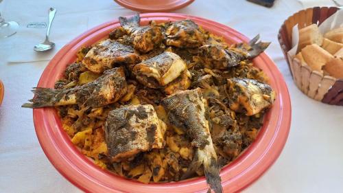 a red plate of food with fish and rice at Le Patio de Mezraya in Mezraya