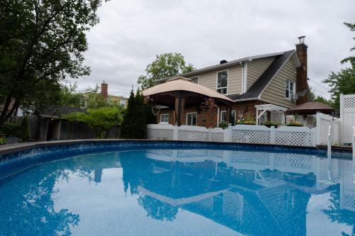 a house with a swimming pool in front of a house at Au coq du bonheur in Magog-Orford