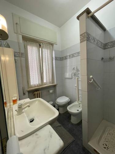 a white bathroom with a sink and a toilet at Appartamento a pochi passi dal mare e dal centro in LʼAmericano