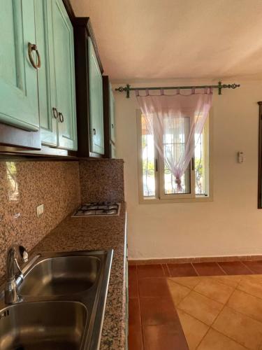 a kitchen with a sink and a window at Villa Su Trechesu in Orosei