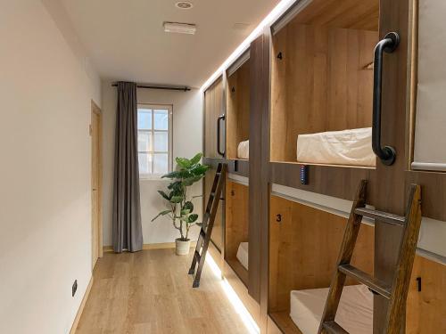 バレンシアにあるThe POD Suite Hostelの小さなお部屋で、二段ベッドとはしごが備わります。