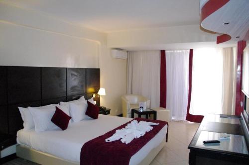 a bedroom with a large bed with a red and white blanket at Anezi Tower Hotel in Agadir