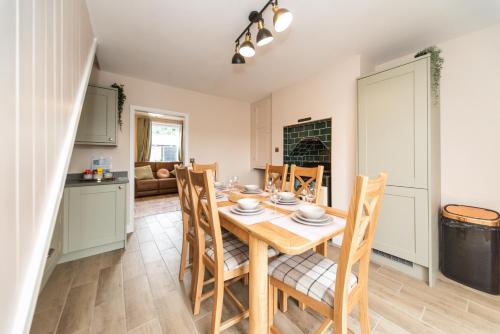 a kitchen and dining room with a wooden table and chairs at The Bell Chime, renovated 3 bedroom cottage in Matlock in Matlock Bank