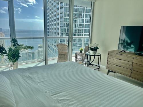 a bedroom with a large bed and large windows at Sun&Sea IconBrickell Unit in Miami