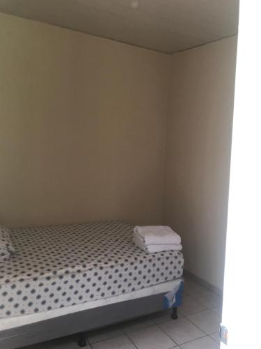1 dormitorio pequeño con 1 cama con 2 toallas en shaylas, en Santa Ana