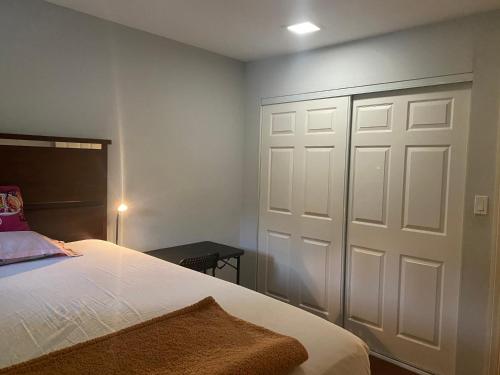 - une chambre avec une porte blanche et un lit dans l'établissement Cosy & Peaceful Place in LA, à Hacienda Heights