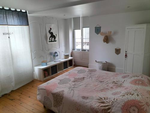 ein Schlafzimmer mit einem großen Bett und einem Fenster in der Unterkunft La maison des remparts in Falaise