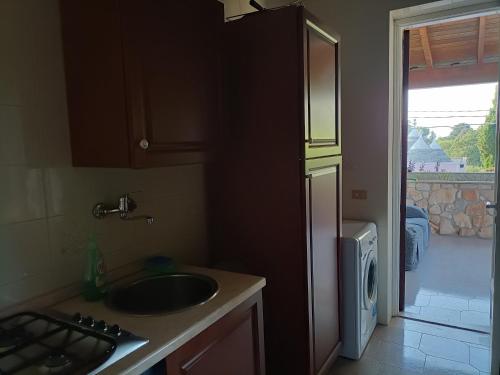 a kitchen with a sink and a door to a yard at La casetta di Fiore in Selva di Fasano