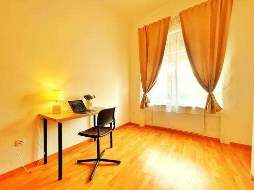 een kamer met een bureau, een stoel en een raam bij Central Spacious Flat in Boedapest