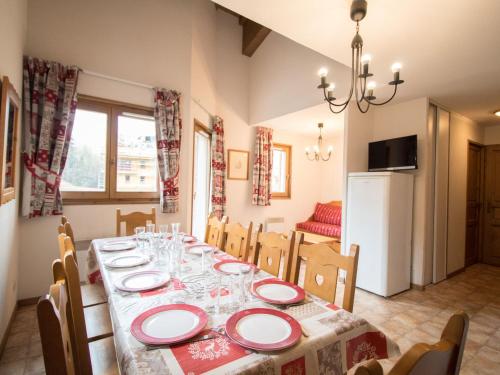 une salle à manger avec une table avec des assiettes et des verres à vin dans l'établissement Duplex pour 10 pers, au pied des pistes, proche télécabine et commerces, parking inclus - FR-1-508-16, à Lanslevillard