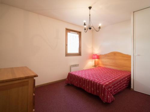 - une chambre avec un lit doté d'un couvre-lit rouge dans l'établissement Appartement cosy 5 pers. au pied des pistes à Val Cenis, terrasse, parking, proche commerces - FR-1-508-159, à Lanslevillard