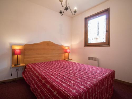 - une chambre avec un lit doté d'un couvre-lit rouge et d'une fenêtre dans l'établissement Appartement spacieux pour 6 personnes avec terrasse au pied des pistes, parking et WIFI inclus - FR-1-508-2, à Lanslevillard