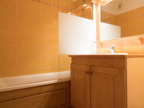 une salle de bain avec un lavabo, un miroir et une baignoire dans l'établissement Appartement spacieux pour 6 personnes avec terrasse au pied des pistes, parking et WIFI inclus - FR-1-508-2, à Lanslevillard