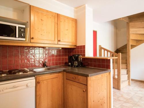une cuisine avec des armoires en bois et un comptoir dans l'établissement Duplex 10 pers au pied des pistes avec parking, balcon et wifi à Val Cenis - FR-1-508-25, à Lanslevillard
