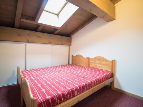 - une chambre avec un lit en bois et une couverture rouge dans l'établissement Duplex 10 pers au pied des pistes avec parking, balcon et wifi à Val Cenis - FR-1-508-25, à Lanslevillard