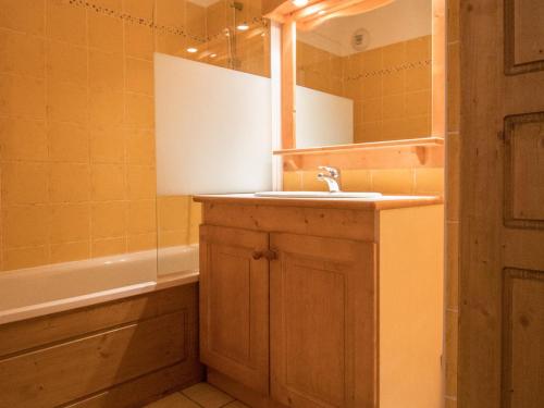 une salle de bain avec un lavabo, un miroir et une baignoire dans l'établissement Appartement cosy au pied des pistes - 6 pers, 40m², terrasse, parking, proche commerces et services - FR-1-508-13, à Lanslevillard