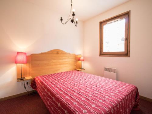- une chambre avec un lit doté d'un couvre-lit rouge et d'une fenêtre dans l'établissement Spacieux appartement 6 pers au pied des pistes avec balcon et parking – Val-Cenis - FR-1-508-8, à Lanslevillard