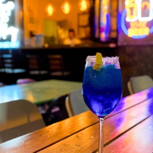 a blue drink sitting on top of a wooden table at Urban Oasis Resort, Tarlac in Tarlac