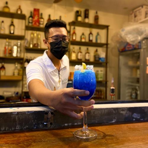 a man wearing a mask holding a blue drink at Urban Oasis Resort, Tarlac in Tarlac