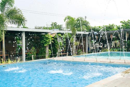 a large swimming pool with water fountains at Urban Oasis Resort, Tarlac in Tarlac