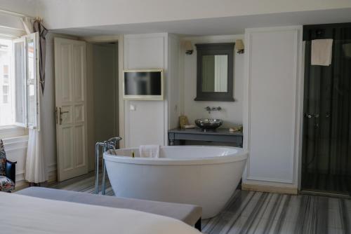 a white bath tub in a bathroom with a sink at Vintage Hotel Alacati in Alaçatı