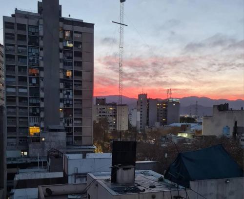 Blick auf eine Stadt bei Sonnenuntergang mit Gebäuden in der Unterkunft Monoambiente 76 in Mendoza