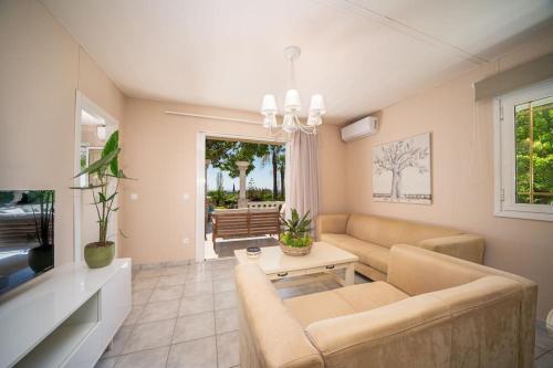 a living room with a couch and a tv at Gaia Residences with lush garden and pool in Argostoli