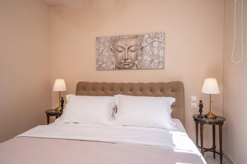 a bedroom with a bed with a headboard and two lamps at Gaia Residences with lush garden and pool in Argostoli