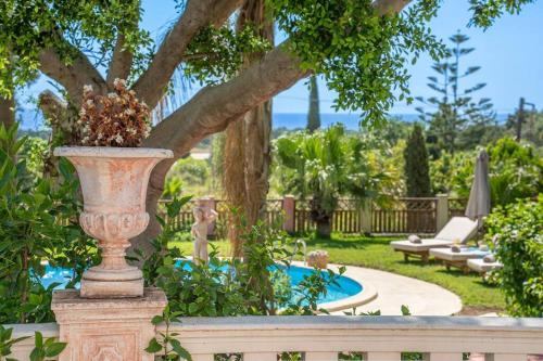 a vase sitting on a fence next to a garden at Gaia Residences with lush garden and pool in Argostoli
