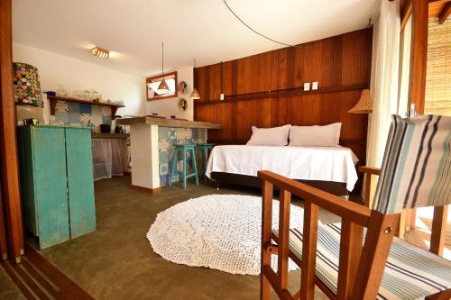 a bedroom with a bed and a table in it at Boa Village- Bungalow com Piscina Natural- Praia de Algodões in Marau