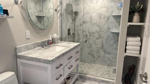 baño blanco con ducha y lavamanos en Sun&Sea IconBrickell Unit, en Miami