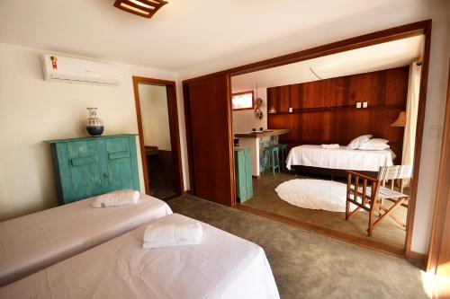 a hotel room with two beds and a mirror at Boa Village- Bungalow com Piscina Natural- Praia de Algodões in Marau