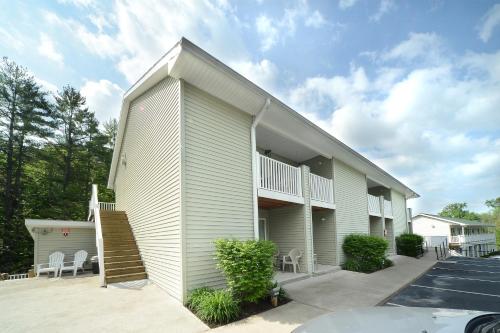a large apartment building with a porch and stairs at Studio Motel of Lake George in Lake George