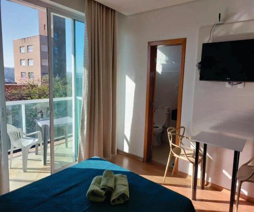 um quarto de hotel com uma cama e uma varanda em Apto com varanda, self check-in, ar, TV e 14km aeroporto em Lagoa Santa