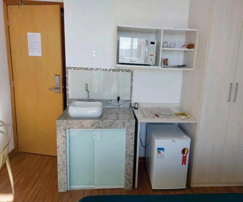uma pequena casa de banho com um lavatório e um espelho em Apto com varanda, self check-in, ar, TV e 14km aeroporto em Lagoa Santa