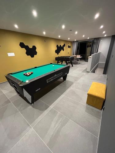 Una sala de estar con una mesa de billar. en Villa d'exception au cœur des montagnes PISCINE & SPA, en Savoie