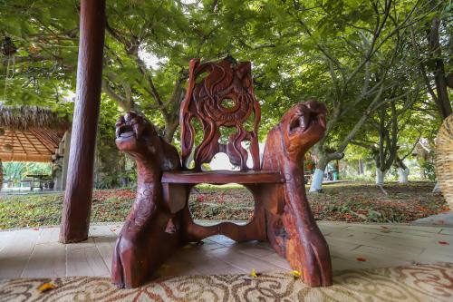 a wooden chair with two people sitting on it at Mayan Secret Hotel Boutique in Chetumal
