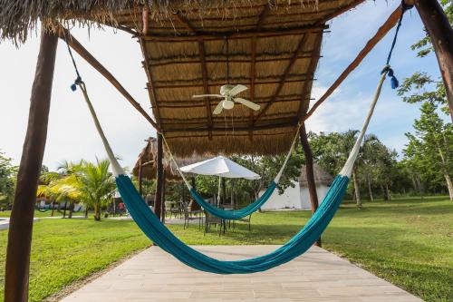 a hammock in a park with an umbrella at Mayan Secret Hotel Boutique in Chetumal