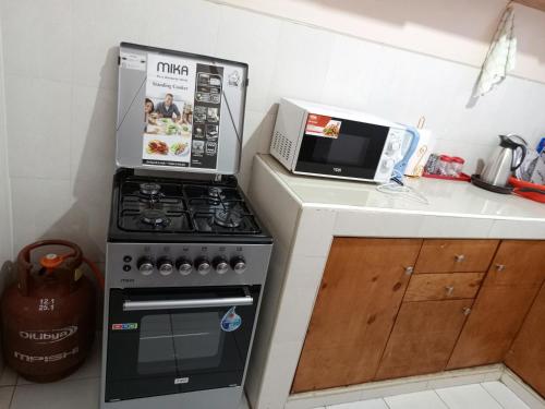 a kitchen with a stove and a microwave at Shukrey palace in Naivasha