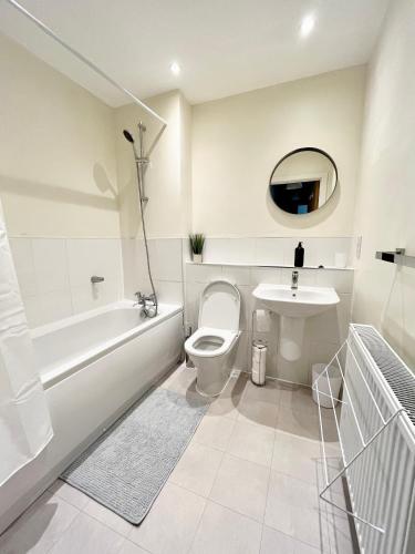 a white bathroom with a toilet and a sink at Modern spacious 2 bed Apartment, close to Gunwharf Quays & Historic Dockyard - Balcony, Smart Tv, Free Parking, WiFi, Double or single beds in Portsmouth