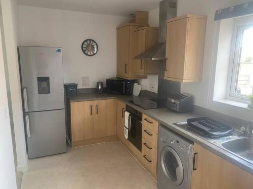 a kitchen with a white refrigerator and a dishwasher at Contemporary Coach House in Newport, Isle of Wight in Newport