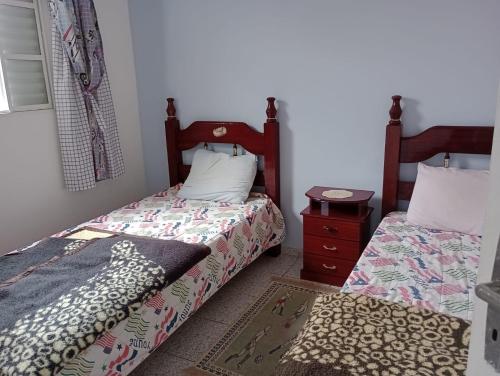 two beds sitting next to each other in a bedroom at Casa para temporada - Campos do Jordão in Campos do Jordão