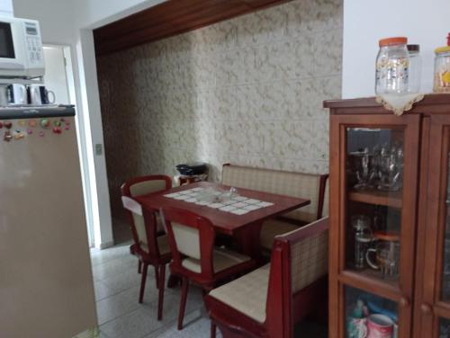 cocina con mesa, sillas y nevera en Casa para temporada - Campos do Jordão, en Campos do Jordão