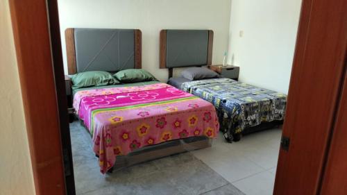 a bedroom with two beds and a mirror at Casa /alberca, chapoteadero, mirador, wifi in Veracruz