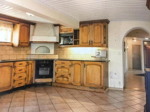 a large kitchen with wooden cabinets and a tile floor at Mark Villan in Örebro