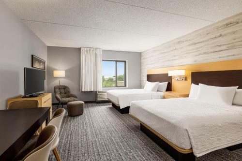 a hotel room with two beds and a flat screen tv at TownePlace Suites by Marriott Harrisburg West/Mechanicsburg in Mechanicsburg
