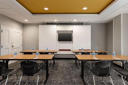 a room with tables and chairs and a projection screen at TownePlace Suites by Marriott Harrisburg West/Mechanicsburg in Mechanicsburg